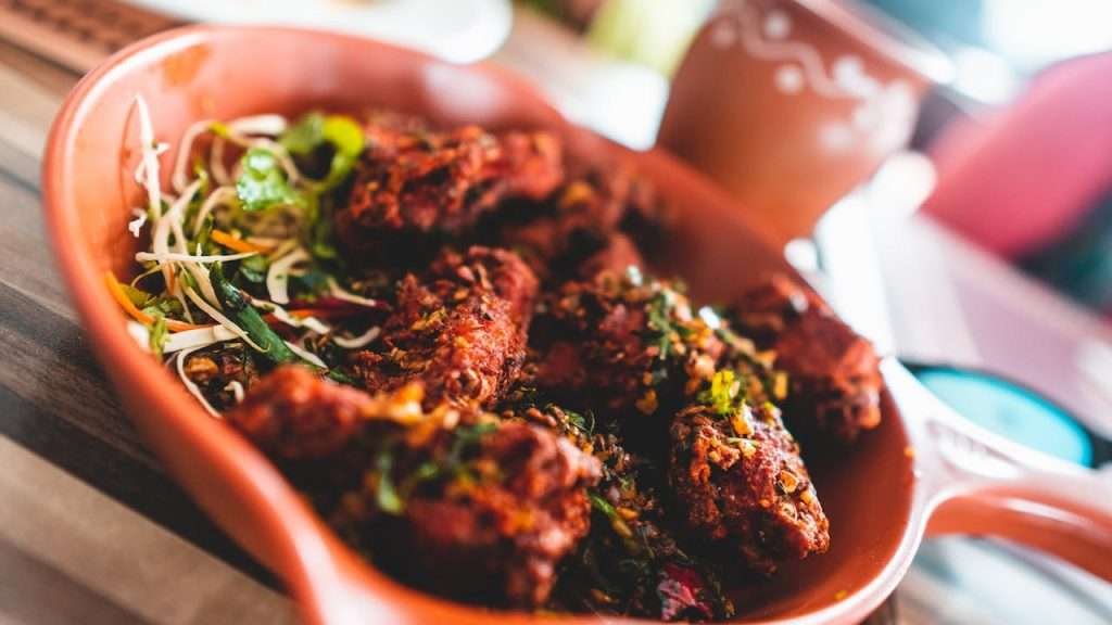pexels-photo-2124699 Close-up of a delicious spicy Indian chicken dish served with fresh garnish, vibrant colors.